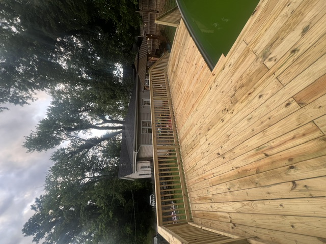 Wide custom deck by Pittman Construction connecting home and backyard gazebo