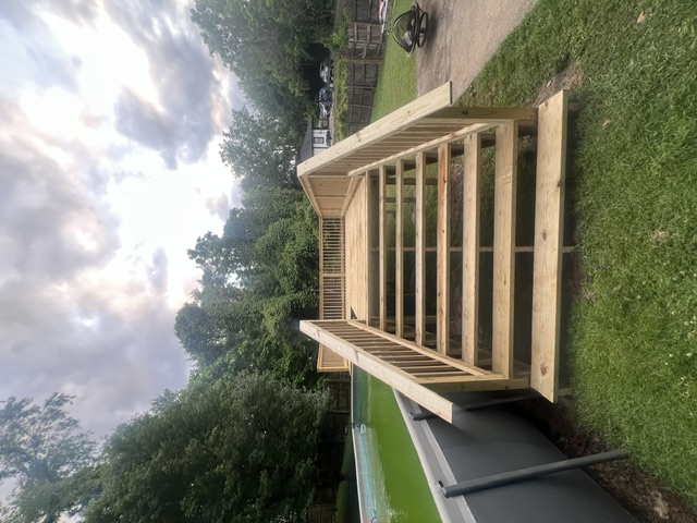 New deck staircase with railings built by Pittman Construction beside an above-ground pool