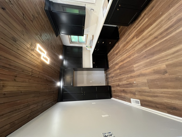 Full kitchen remodel by Pittman Construction — dark cabinetry, new LVP flooring, wood plank ceiling